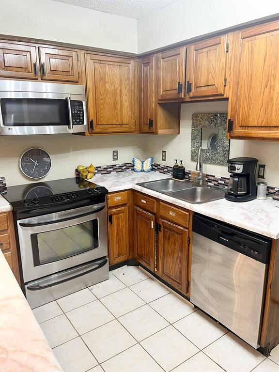 13217 Emily Road, Unit 3103 Dallas, TX 75240 - Photo 13 of 24 a kitchen with a sink stove and microwave