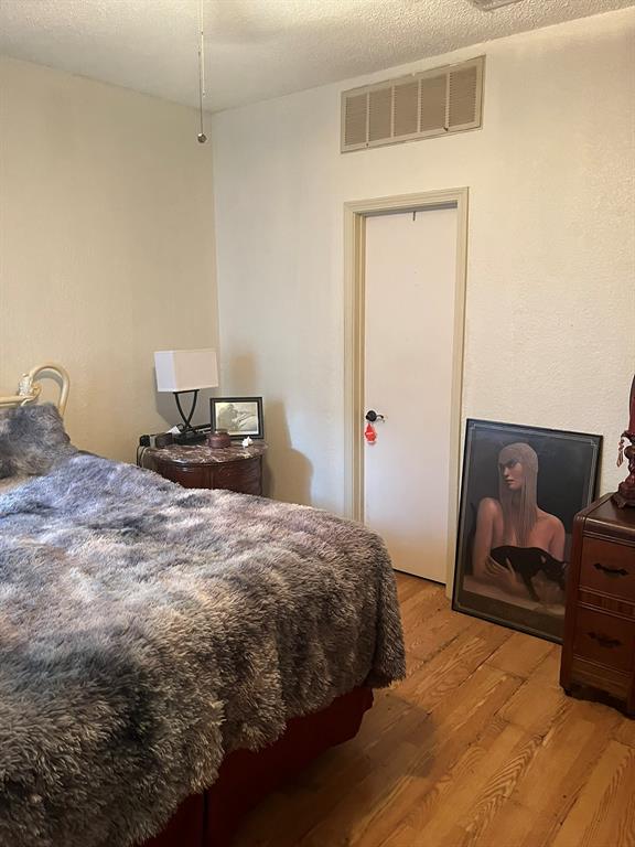 13217 Emily Road, Unit 3103 Dallas, TX 75240 - Photo 15 of 24 a bedroom with a bed and a dresser