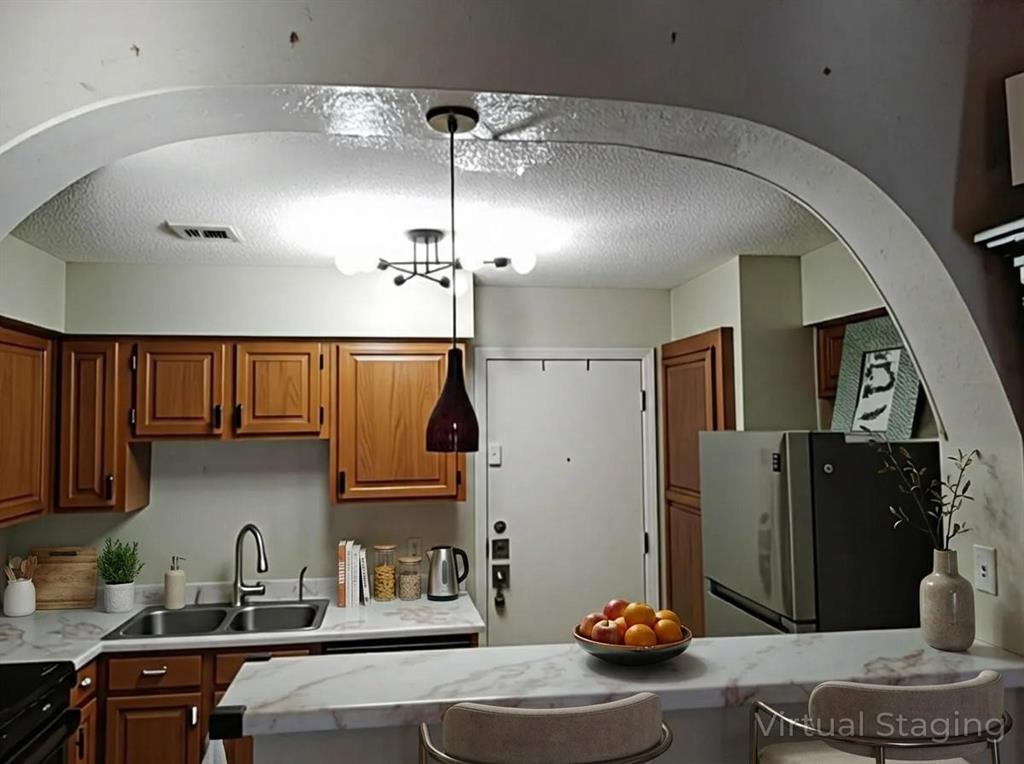 13217 Emily Road, Unit 3103 Dallas, TX 75240 - Photo 3 of 24 a kitchen with stainless steel appliances granite countertop a sink refrigerator and stove