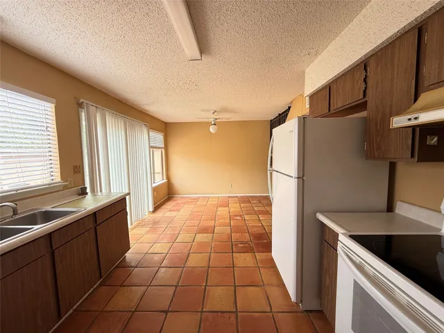 a kitchen with a sink a refrigerator and cabinets
