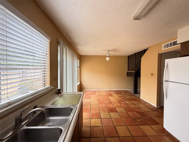 a view of a kitchen with a sink and a refrigerator