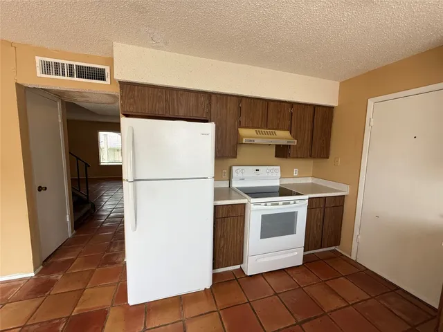 a kitchen with a stove a refrigerator and a sink