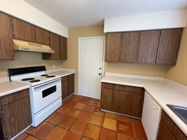 a kitchen with a stove sink and cabinets