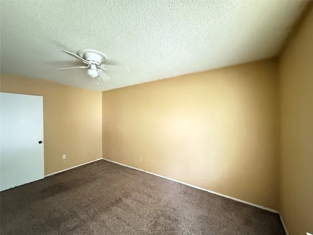 an empty room with a window and a ceiling fan