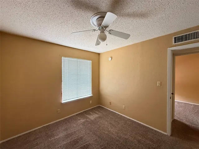 a view of empty room with ceiling fan
