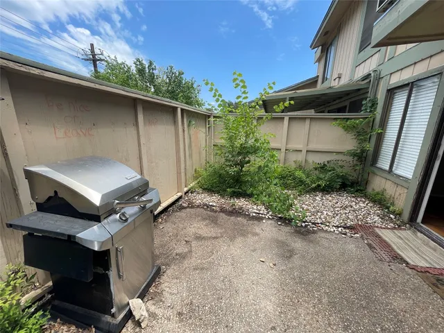 a backyard of a house with plants and barbeque area
