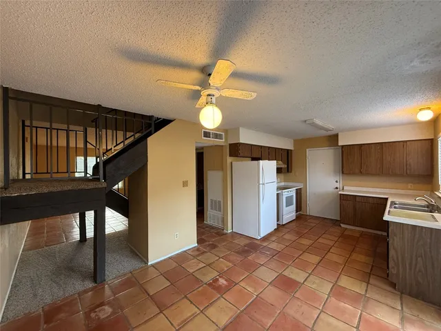 a view of a kitchen with a sink and a refrigerator