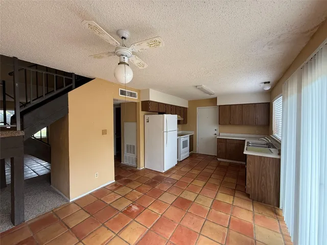 a view of a kitchen with wooden floor and a refrigerator