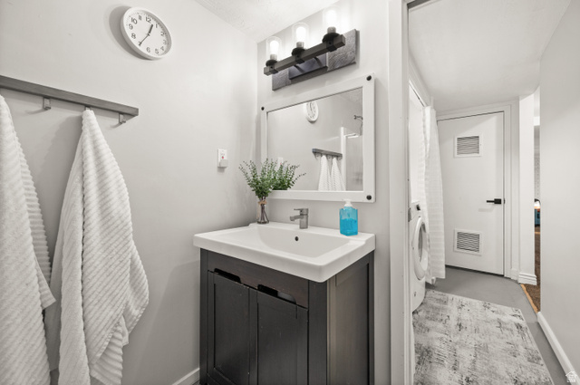 9750 Indian Ridge Drive Sandy, UT 84092 - Photo 35 of 40 Bathroom featuring vanity, concrete floors, and washer / clothes dryer