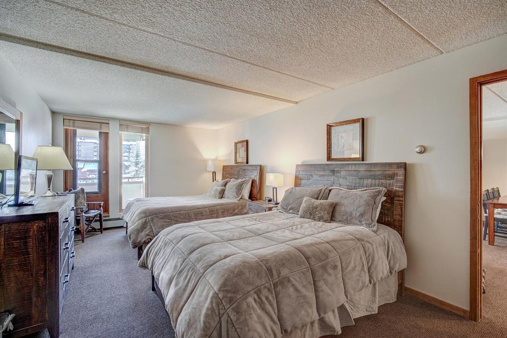 800 Copper Road, Unit 104 Copper Mountain, CO 80443 - Photo 17 of 32 a bedroom with a large bed and a chandelier