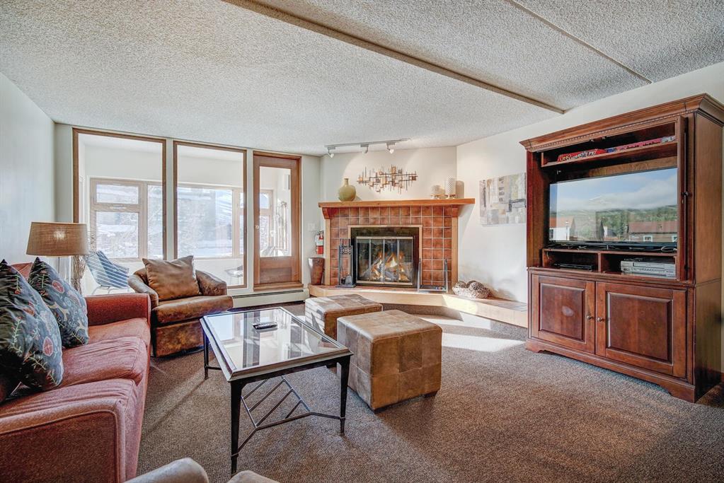 800 Copper Road, Unit 104 Copper Mountain, CO 80443 - Photo 3 of 32 a living room with furniture a flat screen tv and a fireplace