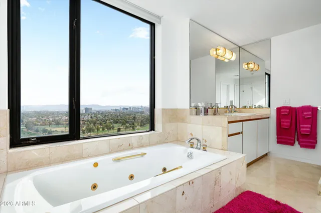 a large bathroom with a tub a sink double vanity and a mirror