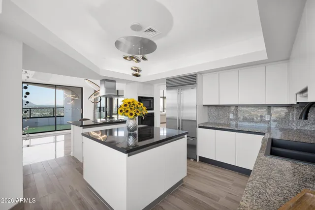 a kitchen with a stove and a view of living room