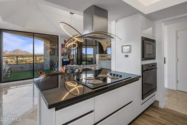 a living room with stainless steel appliances furniture a counter space and wooden floor