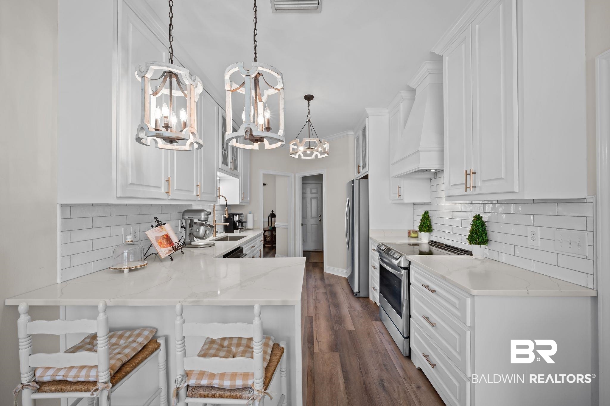 9837 Harmony Ridge Drive Semmes, AL 36575 - Photo 13 of 29 Kitchen with custom range hood, white cabinets, stainless steel appliances, and a chandelier