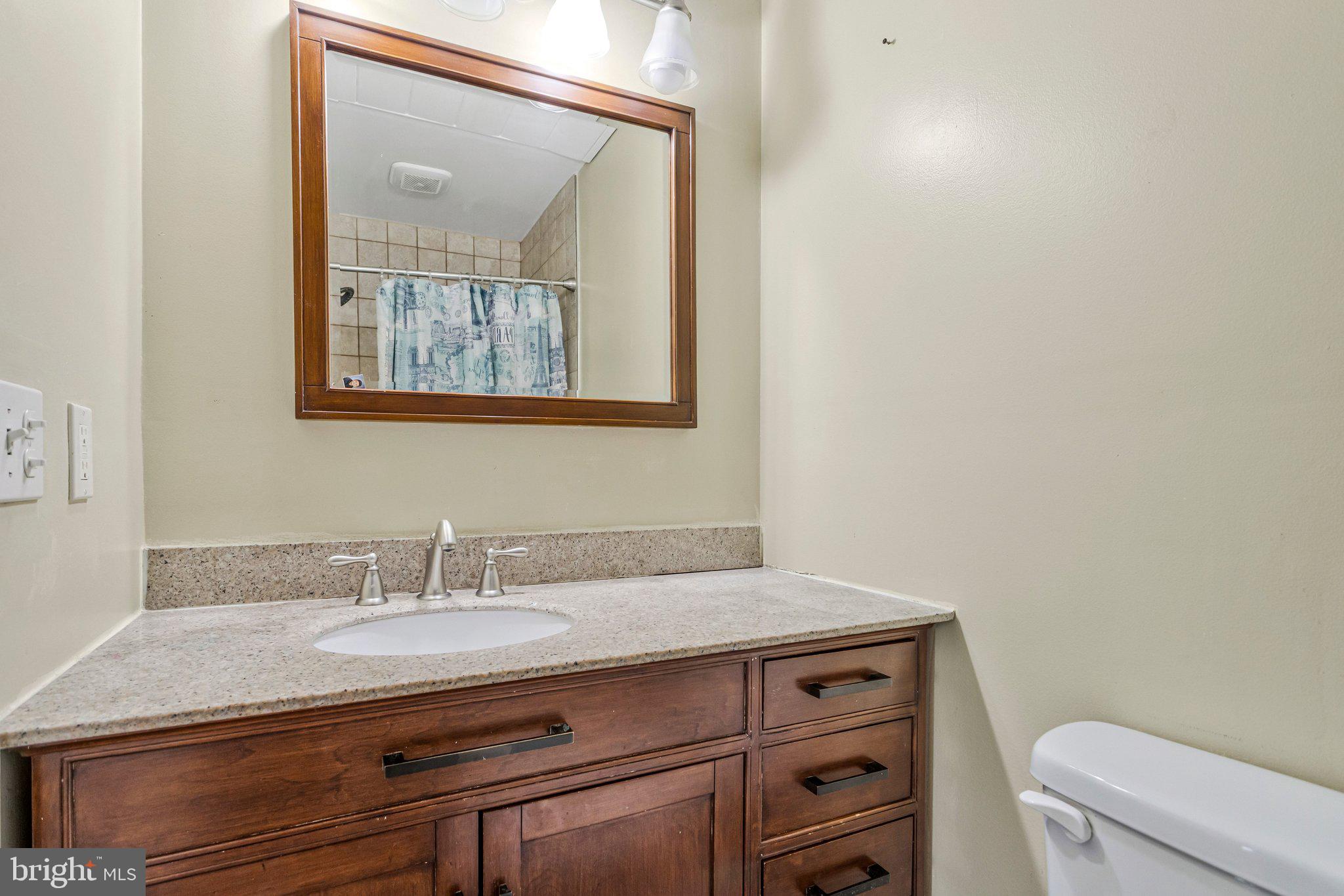 4103 Port Tobacco Road Nanjemoy, MD 20662 - Photo 9 of 19 a bathroom with a granite countertop sink a toilet and mirror