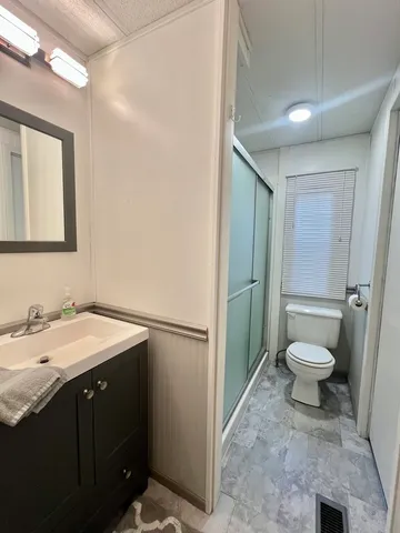 a spacious bathroom with a toilet sink and mirror