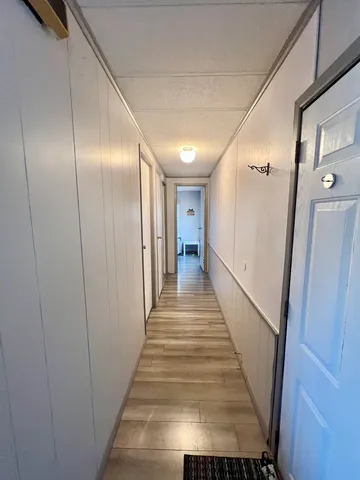 a view of a hallway with wooden floor and staircase