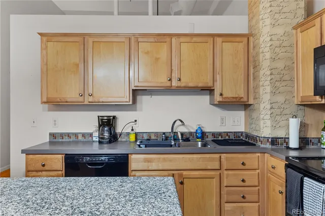 a kitchen with stainless steel appliances granite countertop a stove a sink dishwasher and cabinets with wooden floor