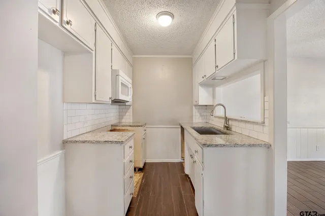 a kitchen with a sink a stove and cabinets