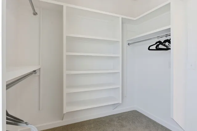 a view of walk in closet with empty racks