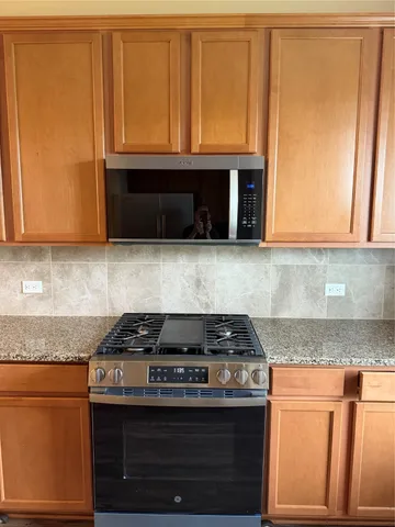 a kitchen with granite countertop cabinets and black appliances