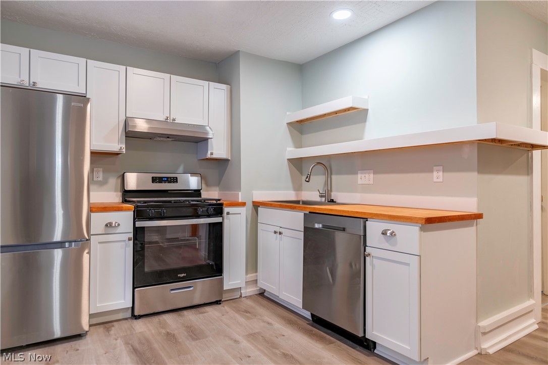 635 Mill Road Ravenna, OH 44266 - Photo 3 of 37 Kitchen with white cabinets, light hardwood / wood-style floors, butcher block countertops, and stainless steel appliances