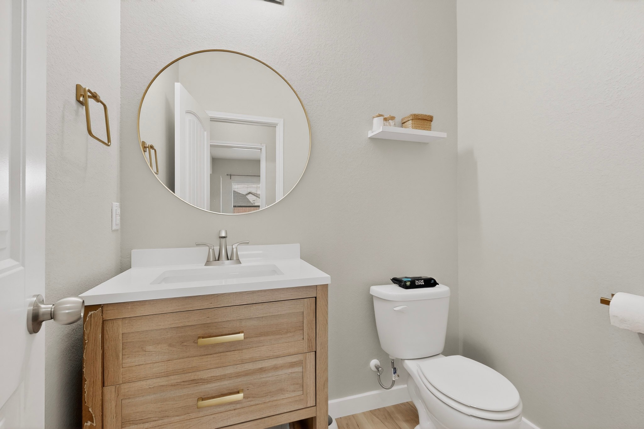 14513 Esker Road Manor, TX 78653 - Photo 24 of 38 1/2 Bath ,A chic bathroom features a modern vanity and elegant circular mirror.