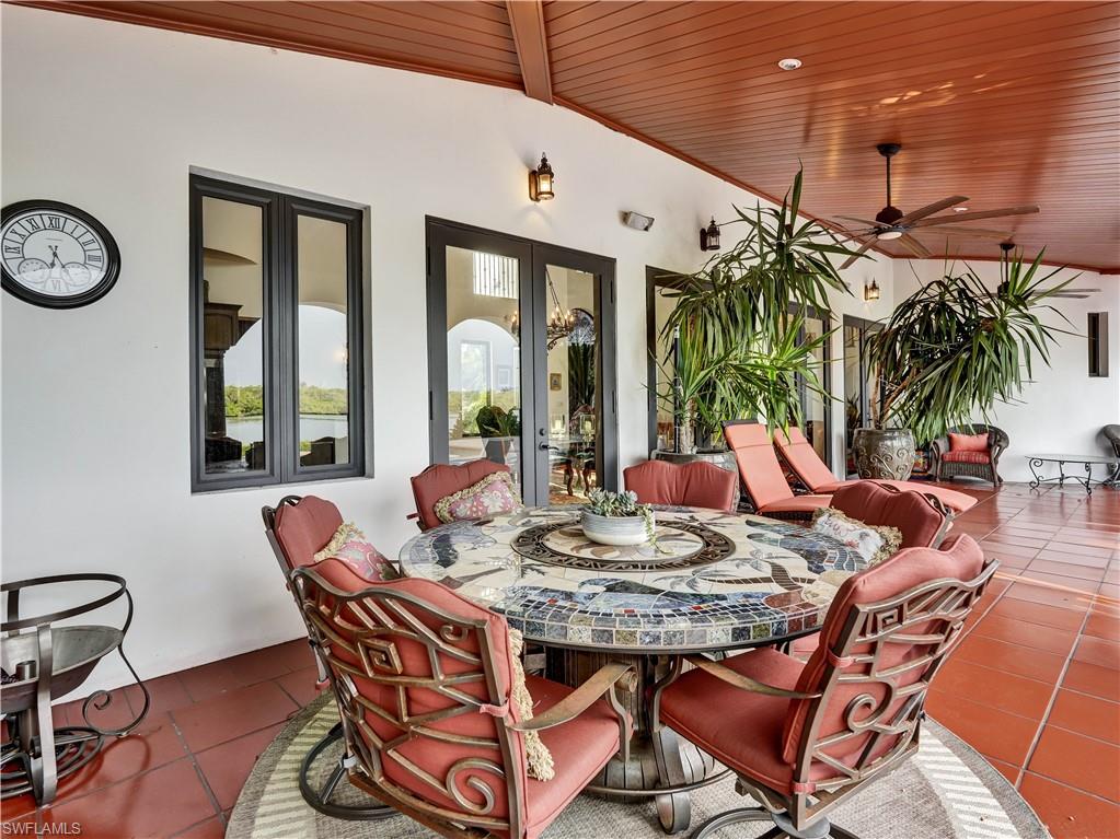 2535 Tarpon Road Naples, FL 34102 - Photo 38 of 50 Expansive paver patio with a rectangular swimming pool featuring a brick coping and integrated spa
