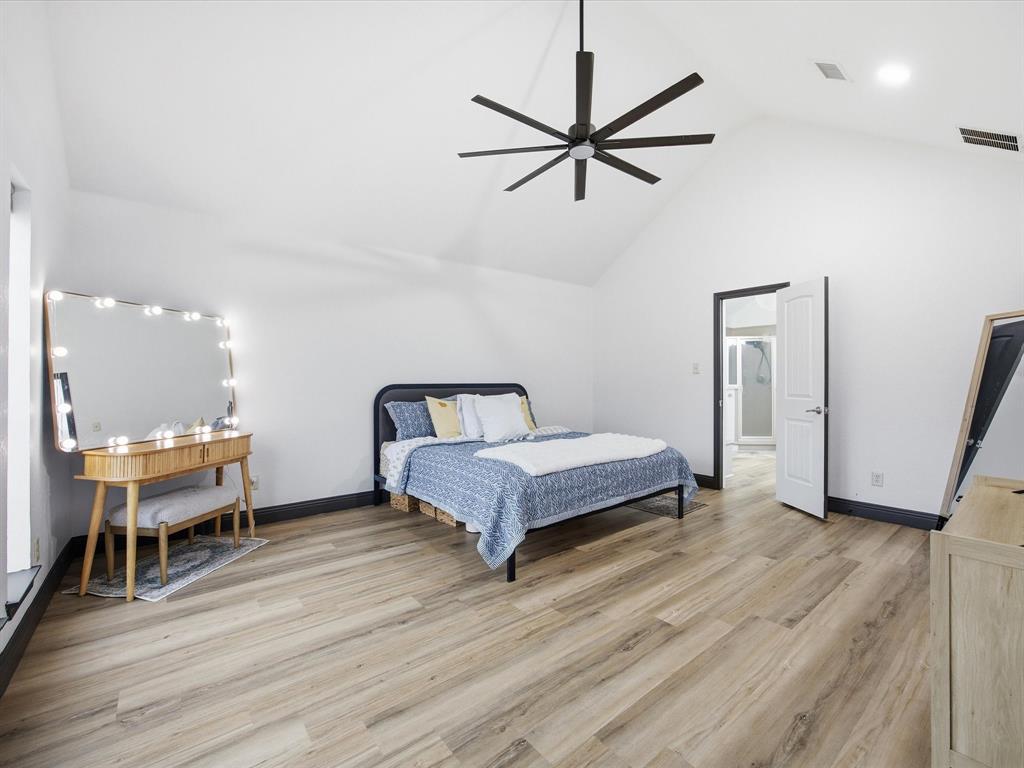 1161 County Road 2175 Decatur, TX 76234 - Photo 11 of 20 a spacious bedroom with a bed and a chandelier