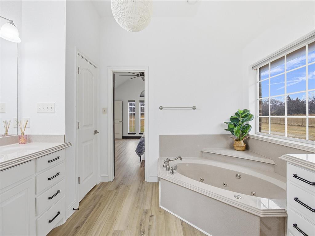 1161 County Road 2175 Decatur, TX 76234 - Photo 15 of 20 a bathroom with a tub a sink and a window