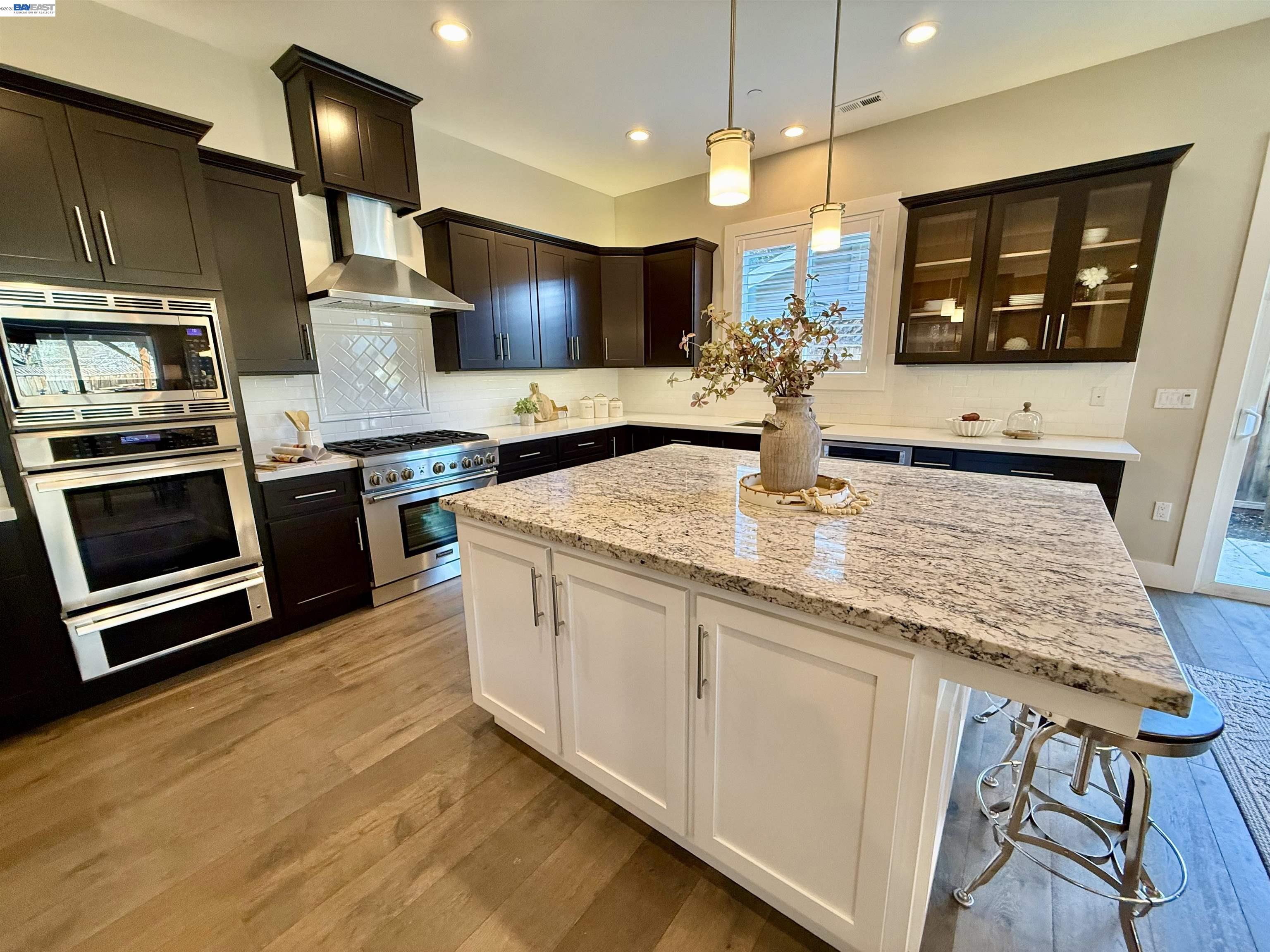 1500 Arroyo Road Livermore, CA 94550 - Photo 23 of 58 a kitchen with stainless steel appliances kitchen island granite countertop a stove a sink and a microwave