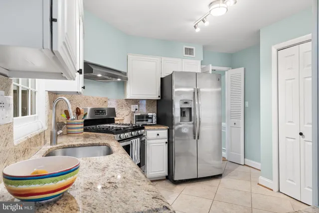 a kitchen with stainless steel appliances a refrigerator a sink a stove and cabinets