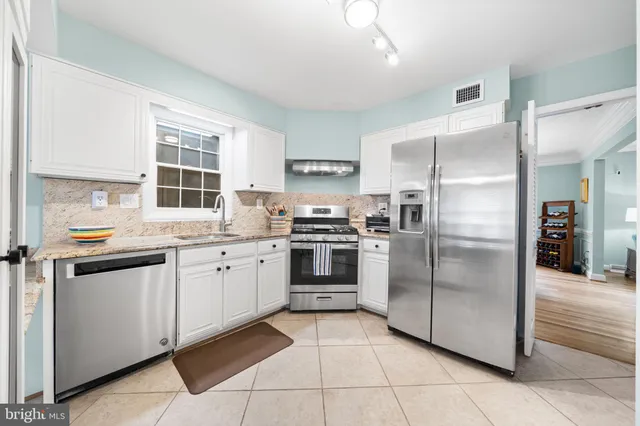 a kitchen with stainless steel appliances granite countertop a refrigerator and a sink