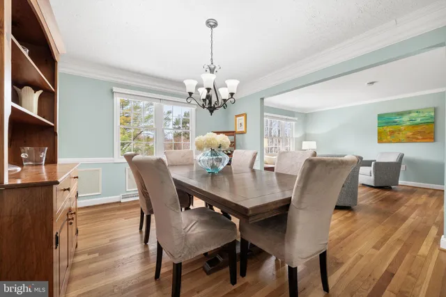 a view of a dining room with furniture a chandelier and wooden floor