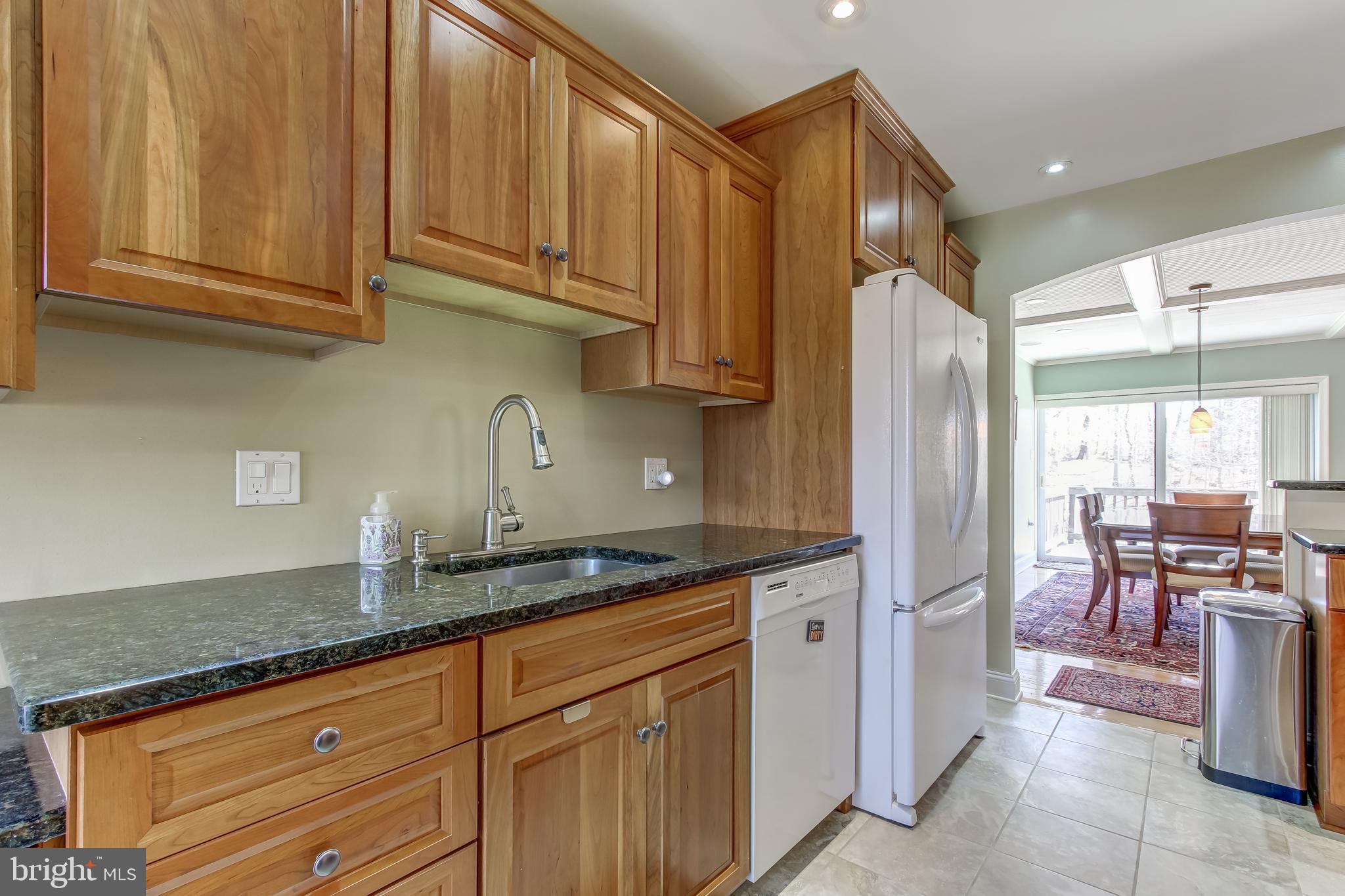 8120 Inverness Ridge Road Potomac, MD 20854 - Photo 11 of 42 a kitchen with granite countertop a sink stainless steel appliances wooden floor and cabinets
