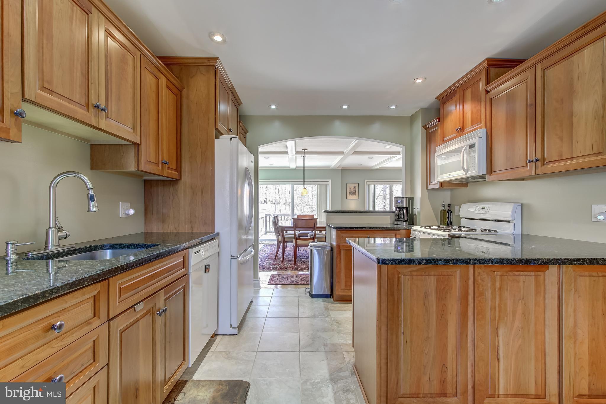 8120 Inverness Ridge Road Potomac, MD 20854 - Photo 10 of 42 a kitchen with kitchen island granite countertop wooden cabinets a sink dishwasher and a stove with wooden floor