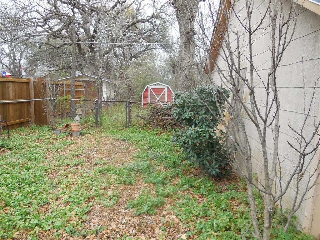 610 West Main Street Ranger, TX 76470 - Photo 13 of 17 View of yard with a storage shed, fence, and an outdoor structure
