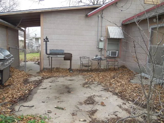 a backyard of a house with chairs and wooden fence