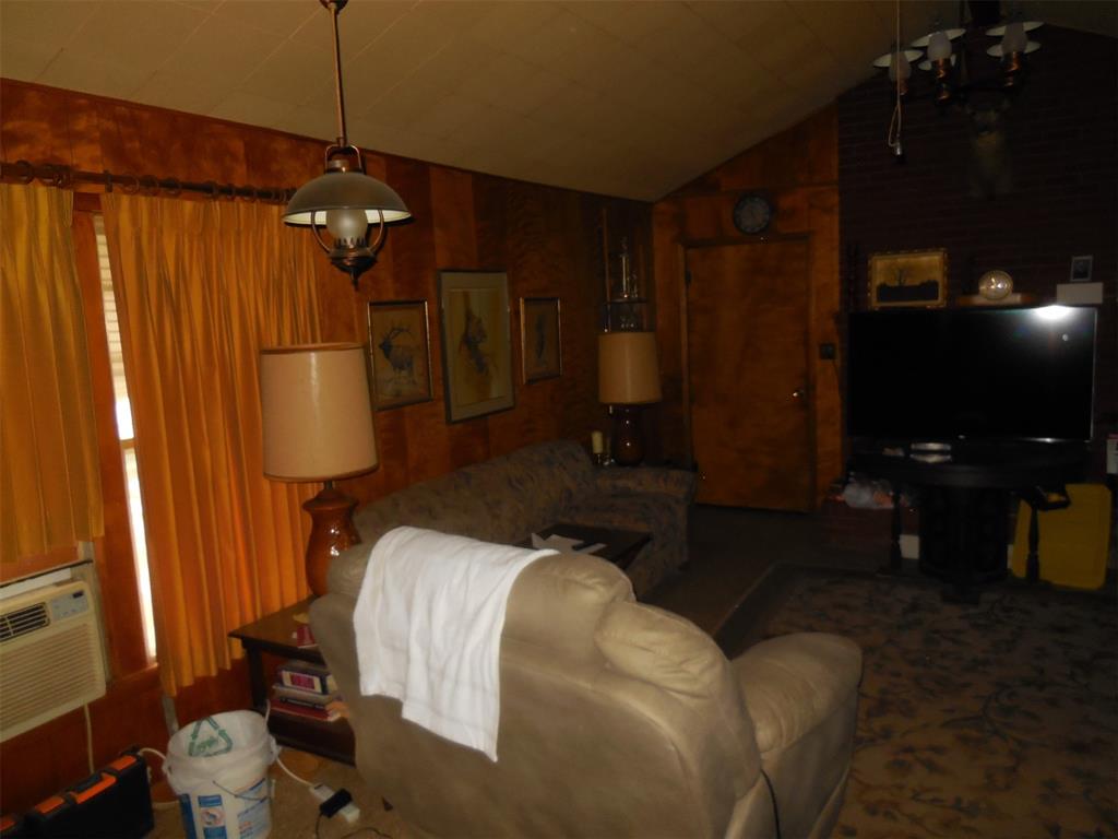 610 West Main Street Ranger, TX 76470 - Photo 15 of 17 Den with lofted ceiling, cooling unit, and wooden walls