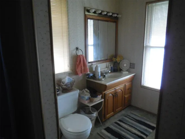 a bathroom with a toilet sink and mirror