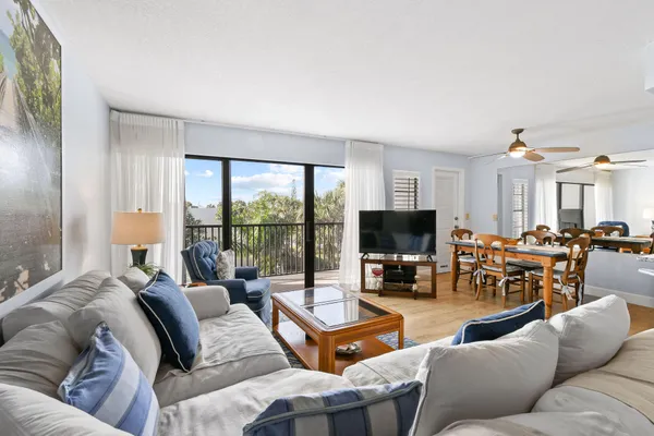 a living room with furniture large window and a flat screen tv