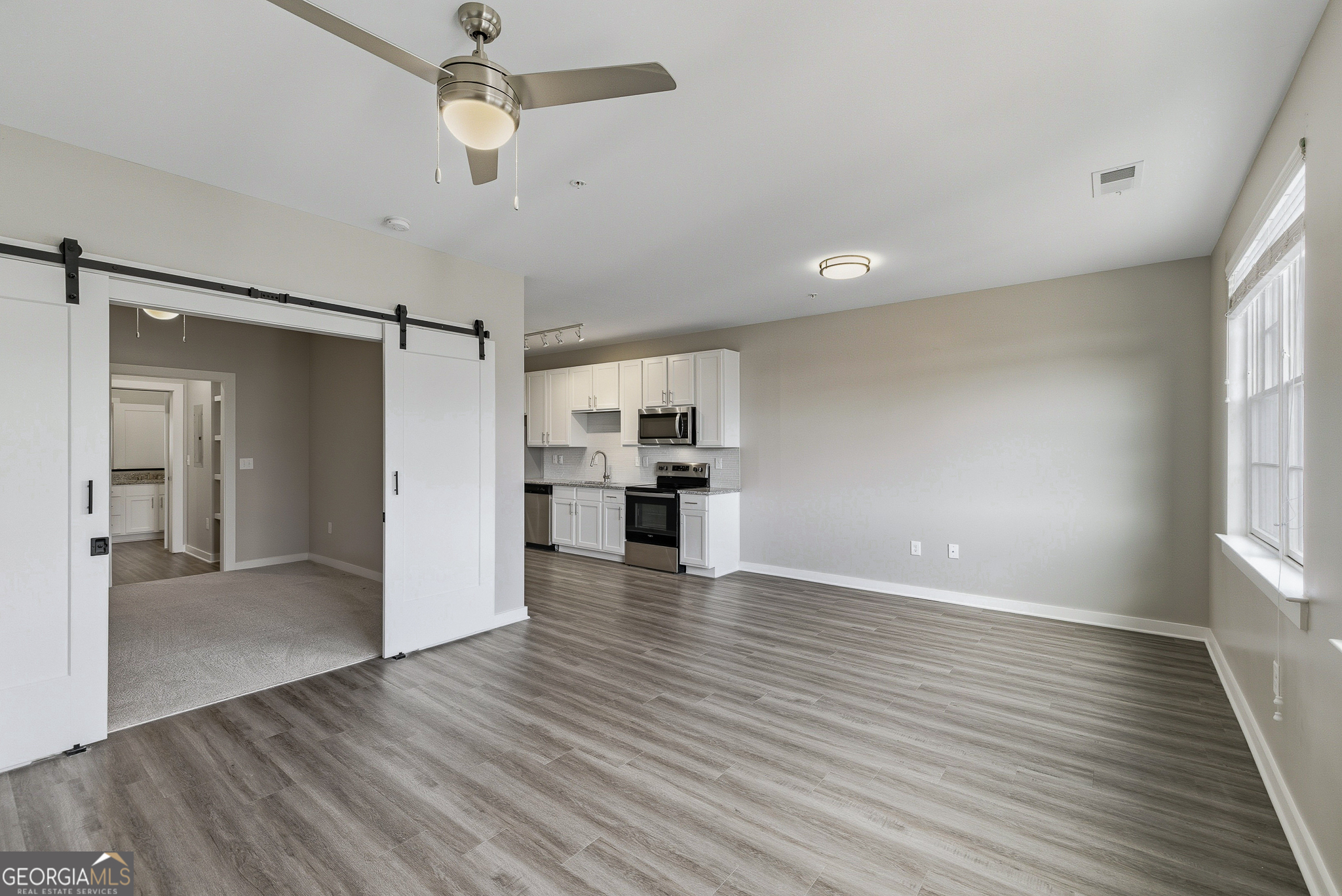 100 Prince Avenue, Unit A303 Athens, GA 30601 - Photo 14 of 27 wooden floor in an empty room with a kitchen