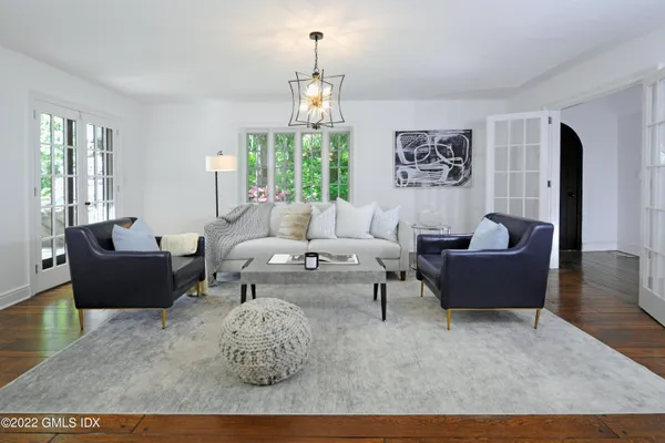a living room with furniture a chandelier and a dining table