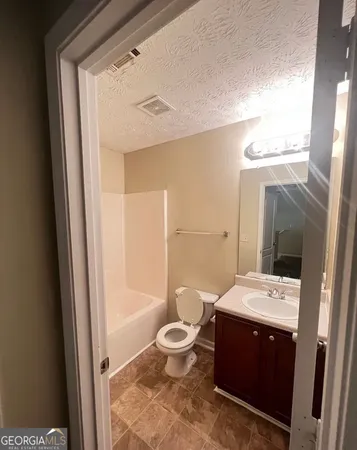 a bathroom with a double vanity sink toilet and shower