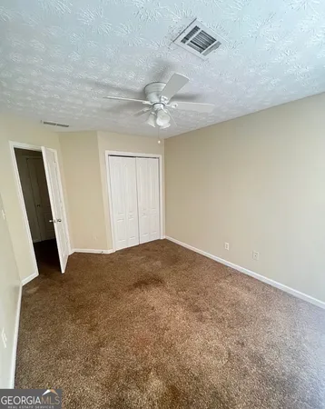 a view of empty room with ceiling fan