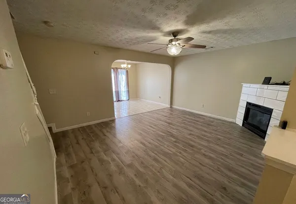 a view of a livingroom with wooden floor and a ceiling fan