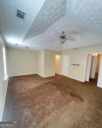 an empty room with a ceiling fan and window