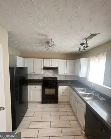 a kitchen with a sink a stove and refrigerator