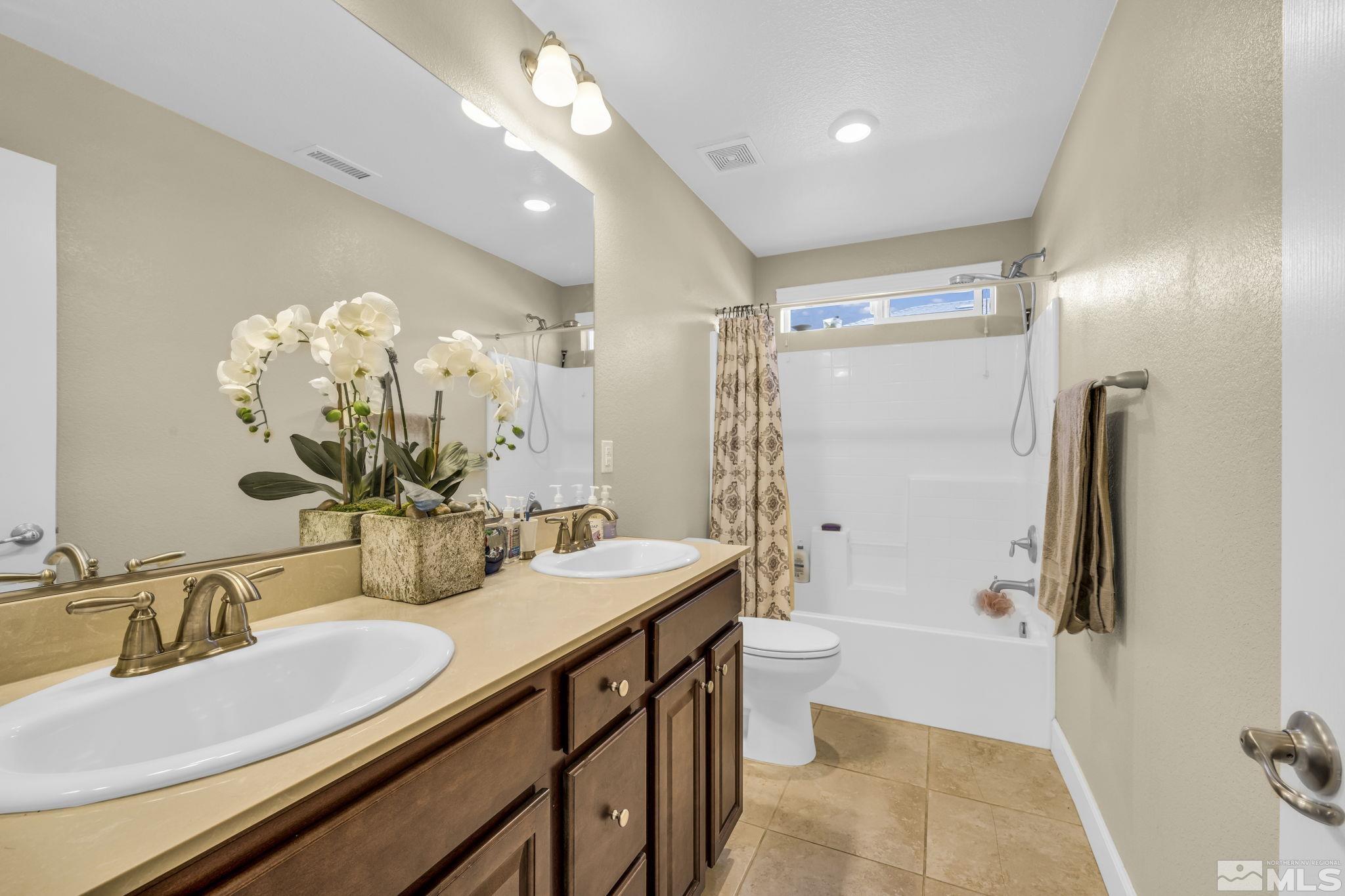6508 Copper Mountain Drive Carson City, NV 89701 - Photo 16 of 40 a bathroom with a double vanity sink mirror double and toilet